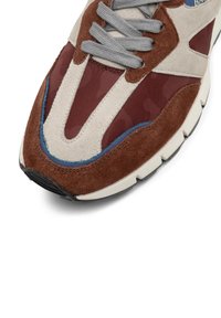 Hnedé a béžové tenisky s prúžkami z semišu a textilu, sivými šnúrkami a modrým akcentom, so štruktúrovanou podrážkou a zaobleným tvarom.