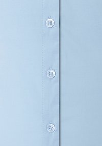 Light blue button-up shirt with a smooth texture, featuring six white buttons along the placket and neat stitching on the seams.