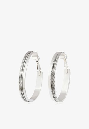 Boucles d'oreilles anneaux en argent avec motif à pois noirs texturé le long du bord extérieur et fermoir à charnière.