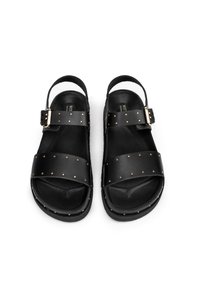 Sandali in pelle nera con due ampie cinghie decorate con borchie dorate, dotati di chiusura con fibbia e schienale aperto per una facile vestibilità.