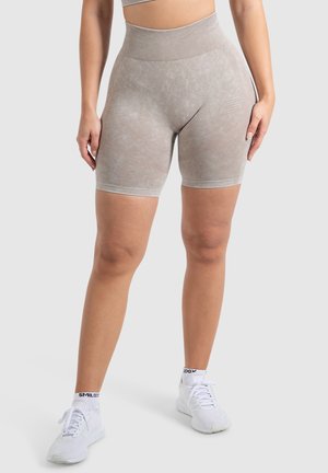 Hoge taille grijze shorts met een gestructureerd patroon en naadloze randen; gemaakt van rekbare stof voor comfort. Gecombineerd met witte sportschoenen.