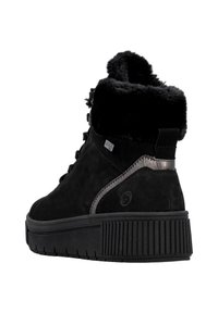 Bottine en suède noir avec col en fausse fourrure, semelle en caoutchouc texturé et accent métallique sur le côté. Design à lacets avec languette rembourrée.