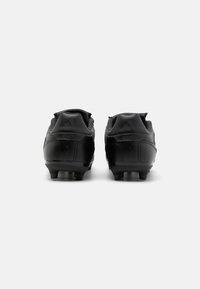 Crampons de football noirs avec une tige synthétique lisse, des accents texturés et des pointes moulées pour l'adhérence. La vue arrière montre le détail du logo.
