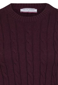Burgundia sweter, mis on varustatud soonilise tekstuuri ja kabelipunutistega. Ümmargune kaelus, millel on silt "FELIX HARDY." Suurus "S."