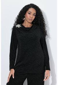 Černý dlouhý rukáv s jemným listovým vzorem, design s rolovacím výstřihem a stříbrná brož ve tvaru květu na levém rameni.