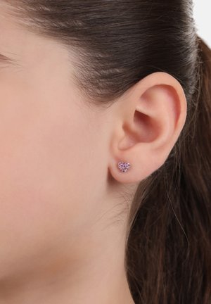 Herzförmige Steckerohrringe mit rosa Edelsteinen, die in einer Metallbasis eingefasst sind, mit einer glänzenden Oberfläche und einem filigranen Design.