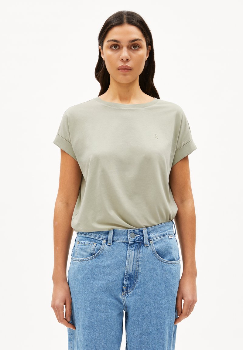 T-shirt verde chiaro a maniche corte con scollo rotondo e maniche arrotolate, realizzato in materiale morbido. Presenta un piccolo logo sul petto.
