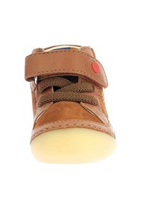 Chaussure en cuir marron avec une finition en daim texturé, une bride Velcro, des lacets marron, des coutures blanches et une semelle en caoutchouc jaune doux.