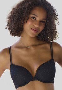 Melnā krūštura ar mežģīņu apdari, ar gludu tekstūru un sirds motīvu. Regulējami siksniņas, kas nodrošina piegulīgu dizainu. Sudraba kaklarota ar "Mīlestības" piekariņu.