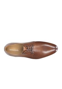 Scarpa in pelle marrone con punta affusolata, design con lacci e superficie liscia. All'interno presenta il nome del marchio "wojas" impresso sulla soletta.