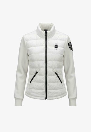 Biała pikowana kurtka z czarnym zamkiem błyskawicznym, dwoma zapinanymi na zamek kieszeniami z przodu, wysokim kołnierzem oraz czarną naszywką na lewym rękawie.