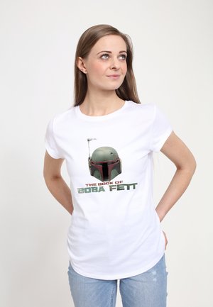 T-shirt en coton blanc avec un graphique du casque de Boba Fett, accompagné du texte "LE LIVRE DE BOBA FETT" en vert et gris foncé, à manches courtes.