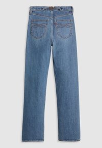Jean en denim bleu vu de dos avec deux poches arrière brodées, des passants de ceinture et une petite étiquette rouge sur la poche droite.