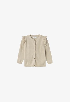 Beige cardigan med lange ermer, volanger på skuldrene, rund halslinning og fem knapper foran. Mykt, strukturert strikket stoff.