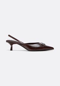 Braune Slingback-Pumps aus Lackleder mit spitz zulaufender Spitze, kleinem Kitten-Heel und dekorativem Metallbesatz am Obermaterial. Mit strukturierter Oberfläche.