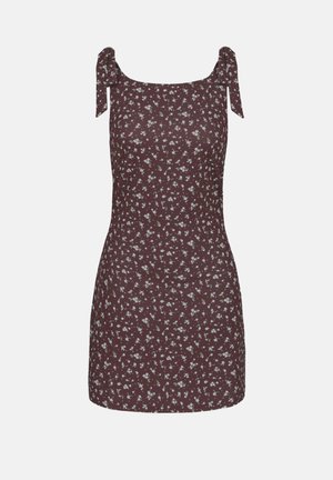 Ermeløs brun minikjole med hvitt blomsterprint og knyttede skulderstropper, tettsittende silhuett, firkantet utringning.