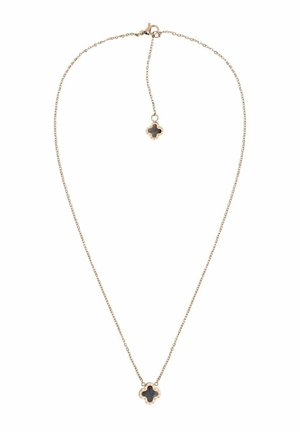 Delicate gouden ketting met zwart klavervormig hangertje en bijpassende kleine klavervormige bedel bij de sluiting op een witte achtergrond.