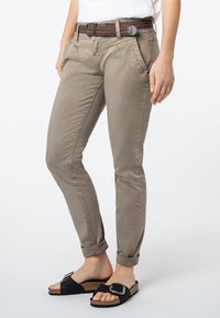 Khaki chino's met een slim fit, met voorzakken, een geweven bruine riem en opgerolde cuffs bij de enkels, gecombineerd met zwarte slidesandalen.