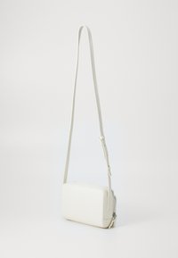 Witte crossbody tas met een rechthoekige vorm. Gemaakt van textuurmateriaal, met een slanke verstelbare strap en een ritsluiting.