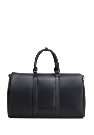 Sac de voyage en cuir noir avec double poignée, détail de la sangle centrale et fermeture éclair sur fond blanc.