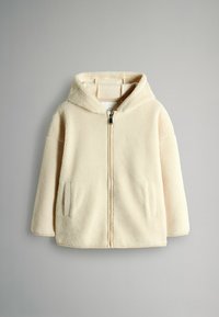 Krémový mikina s kapucňou vyrobená z fleecu, so zapínaním na zips vpredu a bočnými vreckami, vystavená na jednofarebnom svetlošedom pozadí.