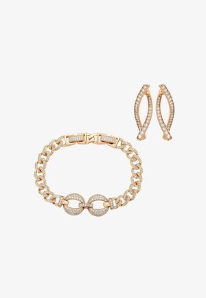 Złota bransoletka z łańcuszkiem i pasujące kolczyki zdobione małymi przezroczystymi kryształkami na białym tle.