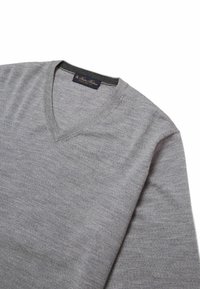 Grijze v-halstrui van soepel breiwerk, met een klassiek ontwerp, lange mouwen en een subtiele ribbels in de halslijn en manchetten.