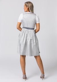 Gray patterned dirndl with a fitted bodice, white puff sleeves, and a pleated skirt. Features a matching gray belt and soft fabric texture.