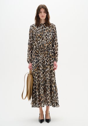 Maxikleid mit Leopardenmuster, langen Ärmeln, tailliertem Schnitt und Rüschensaum. Model hält eine beigefarbene Tasche und trägt schwarze spitze Pumps.