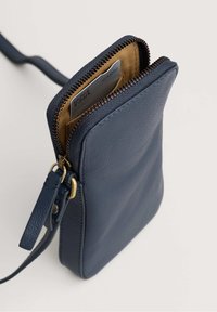 Borsa a tracolla in pelle blu navy con chiusura a zip, caratterizzata da una superficie liscia, accessori in oro e uno slot per schede interno visibile.