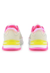 Baskets beige avec des lacets et des accents roses, un amorti jaune au talon, une tige en mesh et une semelle blanche prononcée. Présente un logo sur le talon.