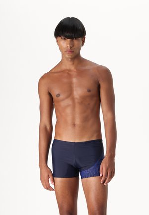 Bañador de marina con un diseño ajustado. Patrón de rayas diagonales azules en el lado izquierdo. Fabricado con un material suave y elástico.