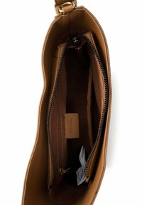 Ruskean nahkalaukun sisusta, jossa on keskellä vetoketjullinen lokero, korttitasku ja sileä vuori. Ominaisuuksiin kuuluu kaareva reuna ja kullanväriset metalliosat.