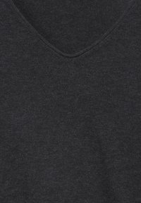 Gros plan sur un tissu tricoté gris foncé à col en V montrant une fine texture côtelée et des détails de couture au niveau de l'encolure.