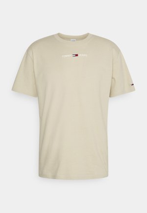 Beżowa bawełniana koszulka z okrągłym dekoltem, krótkimi rękawami i haftowanym logo "TOMMY JEANS" w kolorach czerwonym, białym i niebieskim.