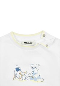 Weißes Baumwoll-T-Shirt mit einem in Gelb akzentuierten Ausschnitt, bedruckter Illustration eines spielenden Hundes und Bären, mit Druckknopfverschluss an der Schulter.