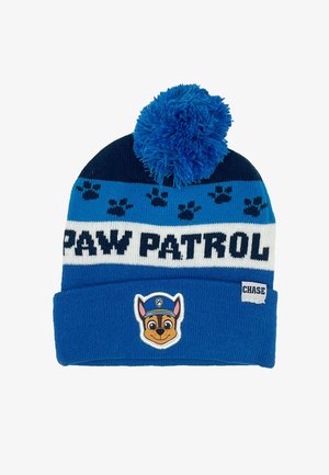 Gorro de punto azul con un gran pompón azul, que presenta el texto "PAW PATROL", patrones de huellas de patas y un parche del personaje Chase en la parte delantera.