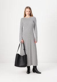 Pikad varrukad, must-valgete triipudega kleit laeva kaelusega, mille juurde kuulub must nahast hobo kott ja mustad pahkluu saapad.