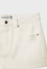 Valkoinen farkkuhame, jossa etutaskut, metallinappikiinnitys ja Stradivariuksen koko 38 -merkki, valmistettu Kambodzassa.