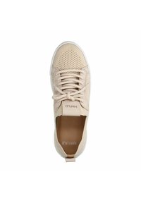 Beige sneaker met een gestructureerde bovenkant met perforaties, vetersluiting en een witte rubberen buitenzool. Merknaam op de tong.