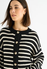 Svart och gräddfärgad randig cardigan i stickad tyg, med rund halsringning, femknappsknäppning och något lös passform.