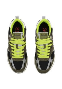 Baskets avec une tige en mesh noir, des accents en daim vert olive, des détails réfléchissants gris, des lacets jaunes vifs et une étiquette de logo rouge.