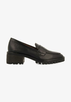 Mocassins en cuir noir avec un talon texturé épais, présentant un bout arrondi et de subtils détails de couture sur la tige.