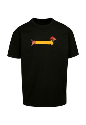 Sort t-shirt med en tegneserieagtig dværghund i en gul kostume med en rød hat og grøn krave, præsenteret tydeligt i midten.