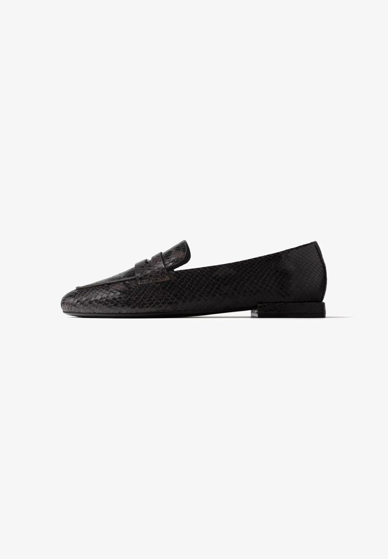 Mocassin noir à petit talon avec texture peau de serpent et une bride sur le dessus, montré de profil sur fond blanc.