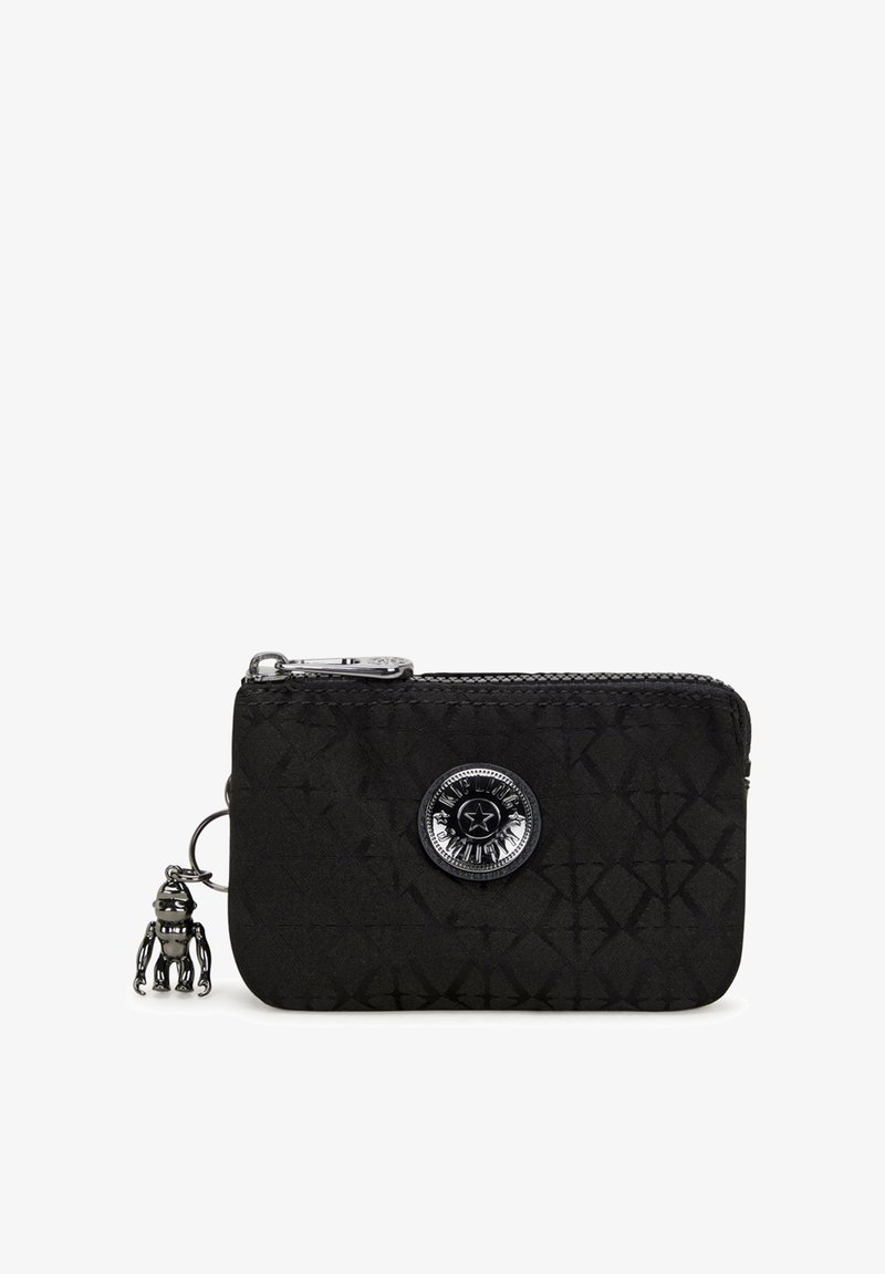 Black zippered wallet made of textured material, featuring a round decorative emblem and a small charm attached by a silver ring.