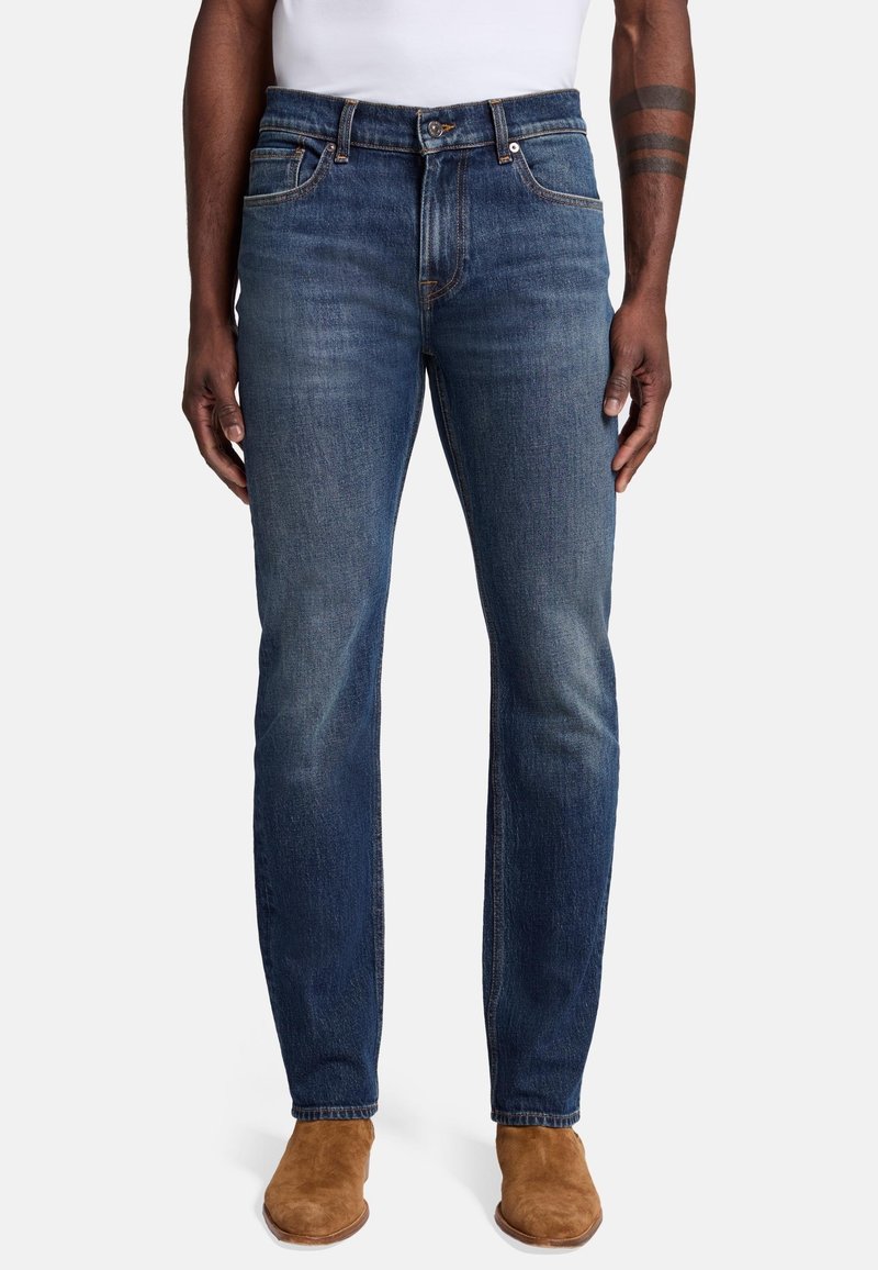 Jeans in denim blu scuro con vestibilità dritta, caratterizzati da un classico design a cinque tasche, leggeri effetti di usura e chiusura con zip e bottone.