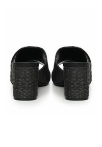 Mule con tacco intrecciato nero, caratterizzate da una parte superiore testurizzata e tacchi a blocco spessi, con design aperto sul retro per una facile calzata.