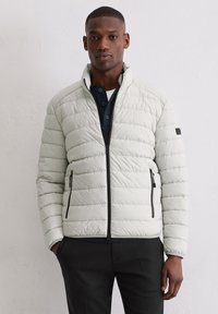 Jasnoszara, pikowana kurtka puchowa z wysokim kołnierzem, czarnymi zamkami i dwoma przednimi kieszeniami. Charakteryzuje się gładką fakturą i dopasowanym krojem.