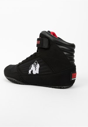 Zwarte hoge sport schoenen met een gestructureerde bovenkant, voorzien van een wit gorilla logo, rode accenten en een klittenbandsluiting.